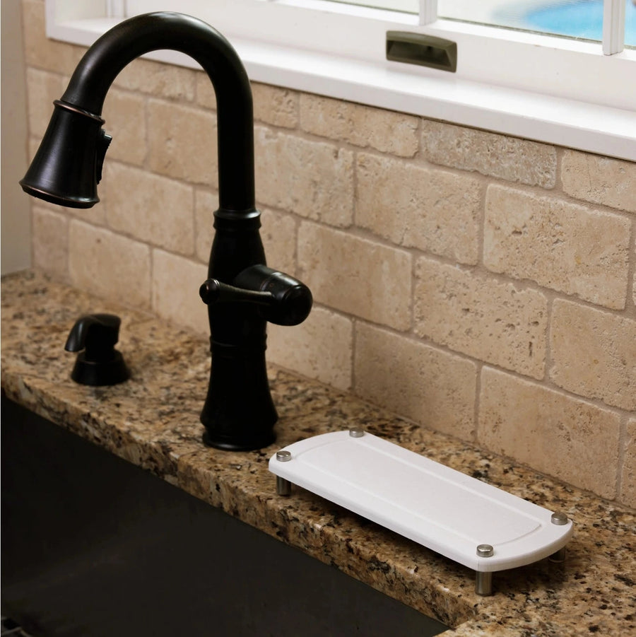 Black faucet on a kitchen counter with a window in the background