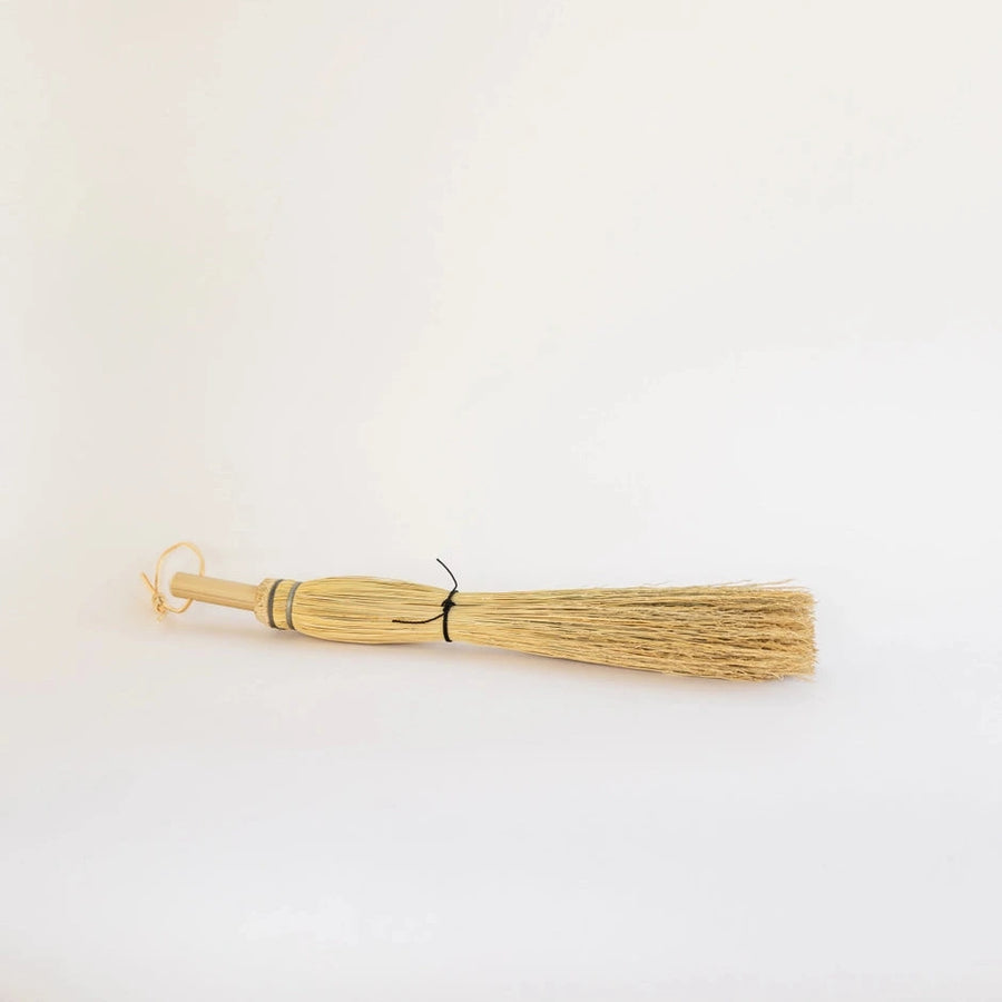 Small broom on a light beige background