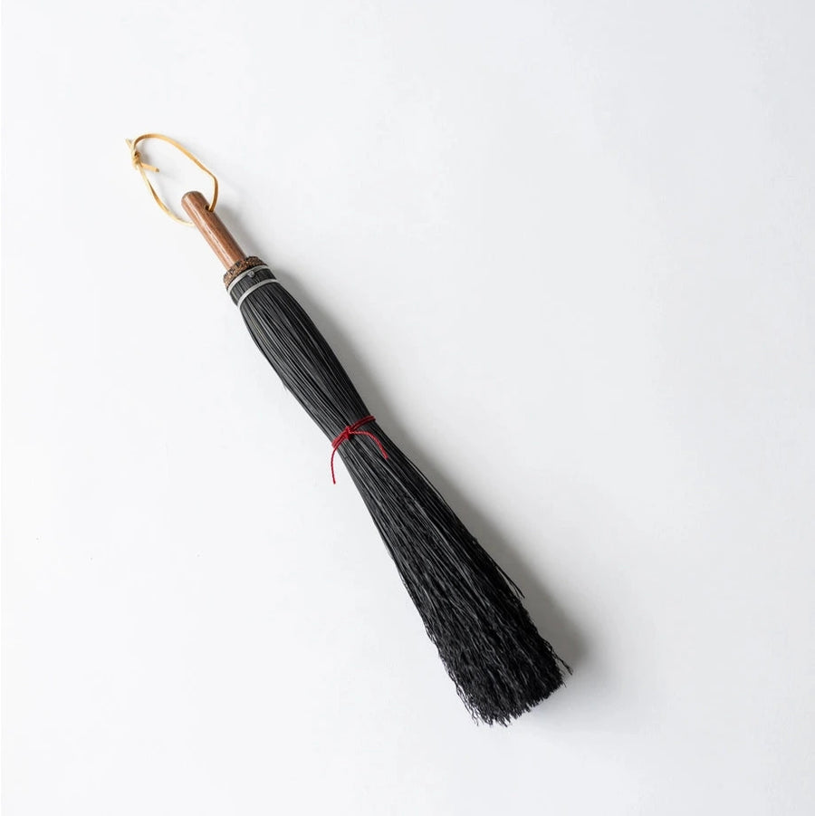 Black brush with a gold handle on a white background